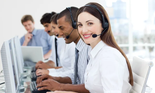 Businesswoman with headset on smiling at the camera — Stock Photo, Image