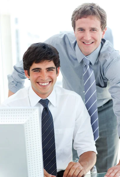Dos ejecutivos masculinos trabajando en una computadora — Foto de Stock