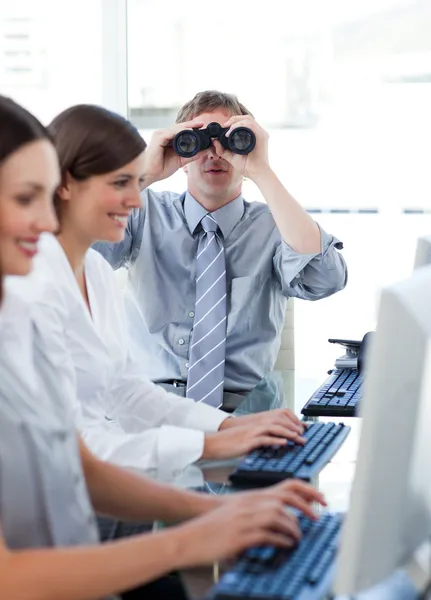 Homem de negócios animado olhando através de binóculos no escritório — Fotografia de Stock