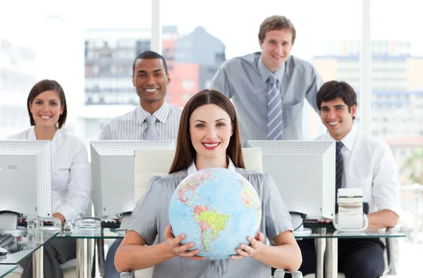 Vacker affärskvinna och hennes team visar en terrestrial globe — Stockfoto