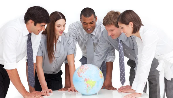 Ett möte mellan företag team runt en terrestrial globe — Stockfoto