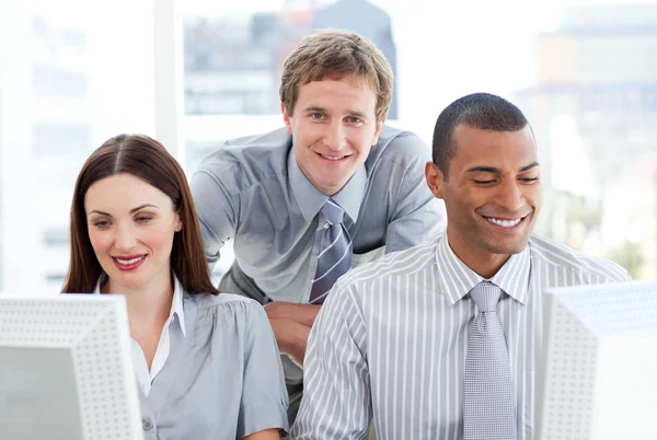 Twee zakenmensen werken op computers met hun manager — Stockfoto