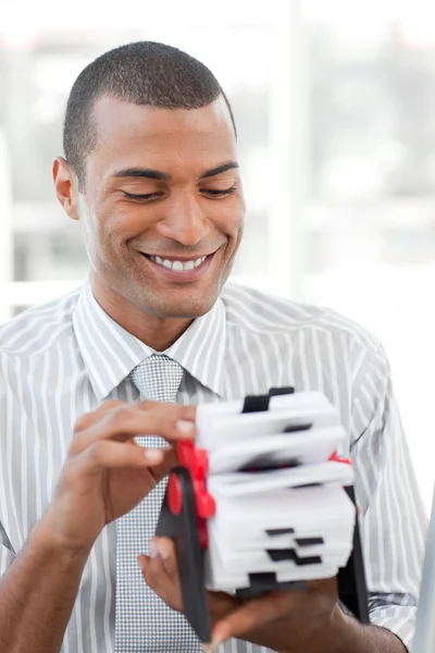 Attractive businessman consulting a business card holder — Stock Photo, Image