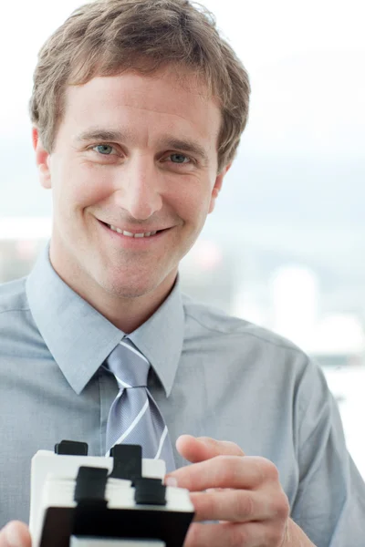 Smiling businessman holding a business card holder — Stock Photo, Image