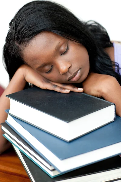 睡觉靠在一堆书上的学生 免版税图库照片