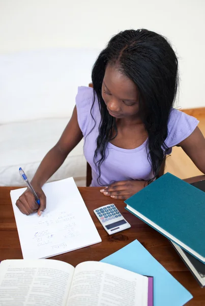Concentrated Afro-American teen girl doing her homework Royalty Free Stock Photos