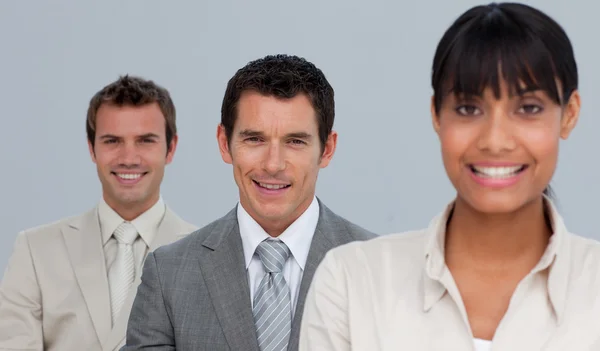 Two businessmen and a businesswoman smiling at the camera Stock Picture