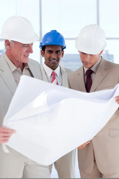 Three engineer co-workers studying plans — Stock Photo, Image