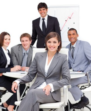 Assertive female executive sitting in front of her team clipart