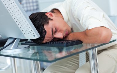 Tired businessman sleeping at his desk clipart