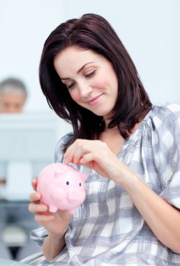 Glowing businesswoman saving money in a piggy-bank clipart