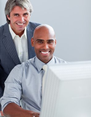 Two elegant businessmen working at a computer clipart