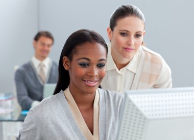 Portrait of two radiant businesswomen working at a computer clipart