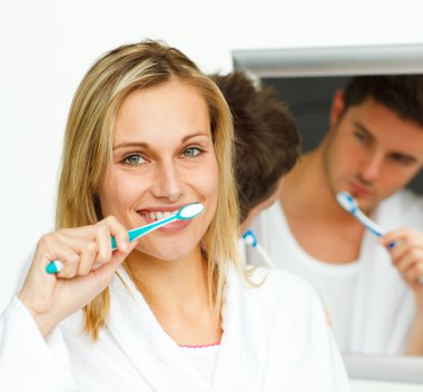 Portrait of an attractive woman cleaning her teeth with her boyf clipart