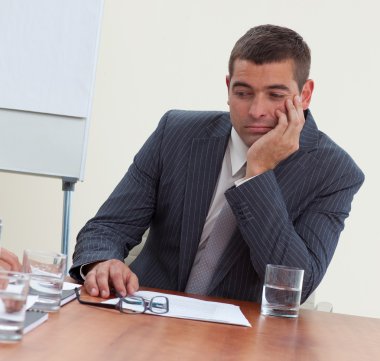 Attractive businessman bored in a meeting clipart