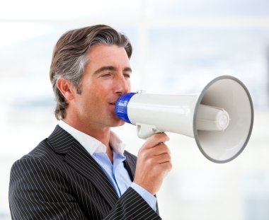 Confident businessman yelling through a megaphone clipart