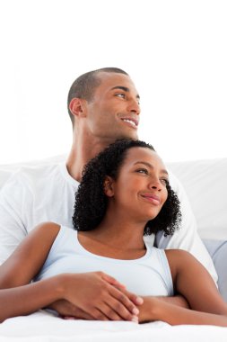 Afro-american lovers hugging on their bed clipart