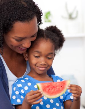 Beautiful girl eating watermelon with her mother clipart