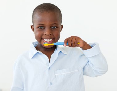 Portrait of a smiling little boy brushing his teeth clipart