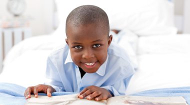 Small boy reading a book clipart