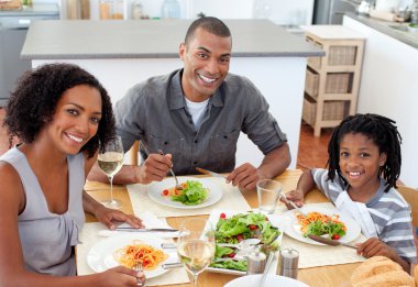 Ethnic couple dining with their son clipart