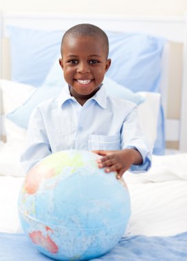 Cute little boy holding a terrestrial globe clipart