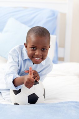 Cute little boy holding a soccer ball clipart