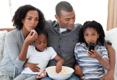 Afro-American family watching a film at home clipart