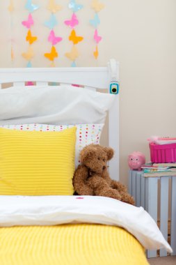 Child's bedroom with a teddy bear on the bed clipart