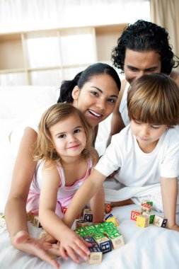 Portrait of a happy family playing with letter blocks clipart