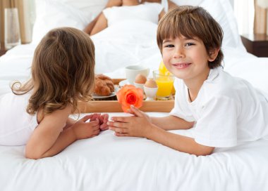 Close-up of siblings bringing breakfast to their parents clipart