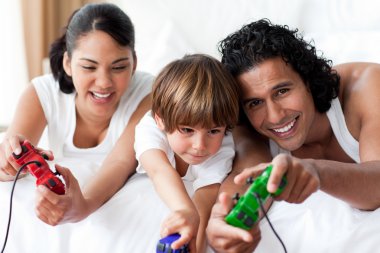 Portrait of smiling parents playing video games with their son clipart