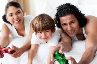 Parents and their little boy playing video games clipart