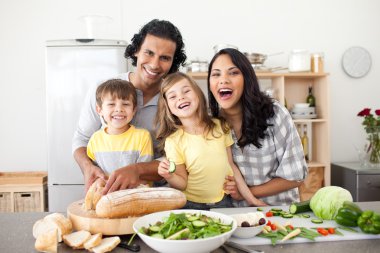 Lively family having fun in the kitchen clipart