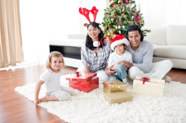 Family playing with Christmas gifts at home clipart