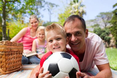 Smiling family ralaxing at a picnic clipart