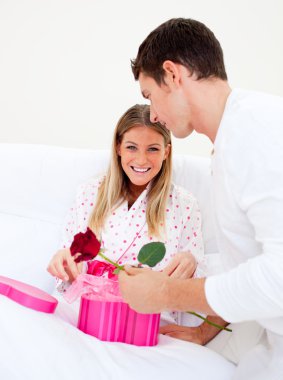 Attractive husband giving a present to his wife clipart