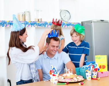 Delighted man celebrating his birthday with his wife and his chi clipart