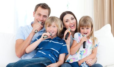 Happy family singing a karaoke together clipart