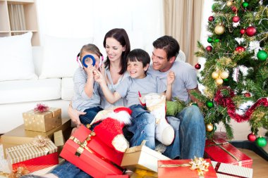 Happy family having fun with Christmas presents clipart