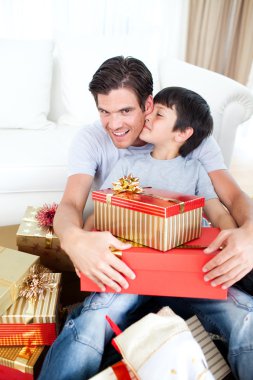 Son kissing his father after receiving a Christmas gift clipart