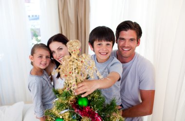 Happy little kid decorating a Christmas tree with his family clipart
