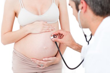 Gynecologist examining a pregnant woman clipart