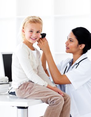 Concentrated female doctor checking her patient's ears clipart