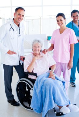 Serious medical team taking care of a senior woman clipart