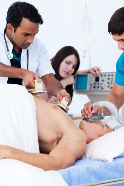 A diverse medical team resuscitating a patient clipart