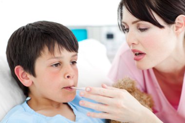 Caring nurse taking her patient's temperature clipart