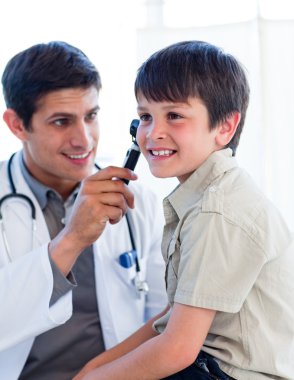 Handsome doctor examining little boy's ears clipart