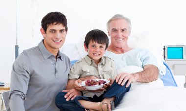 Smiling father and son visiting grandfather clipart