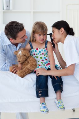 A doctor checking patient's ears clipart